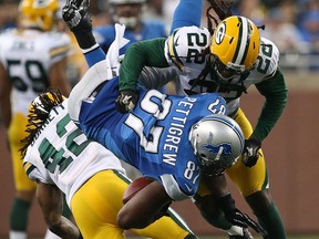 Green Bay's Morgan Burnett, left, and Jerron McMillan, right, tackle Detroit's Brandon Pettigrew at Ford Field. (Photo by Leon Halip/Getty Images)