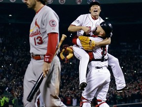 Boston relief pitcher Koji Uehara, top, and catcher David Ross celebrate after Matt Carpenter of the Cards struck out to end Game 6 of the World Series Wednesday. (AP Photo/Matt Slocum)