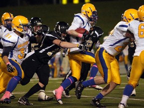 AKO linebacker Mason Beekhuis, centre, tackles Burlington's Brody Essery in 2011. (DYLAN KRISTY/The Windsor Star).
