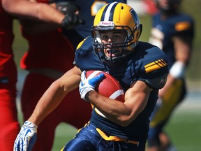 Lancers running back, Mitch Dender carries the ball against the Carleton Ravens at Alumni Field. (DAX MELMER/The Windsor Star)