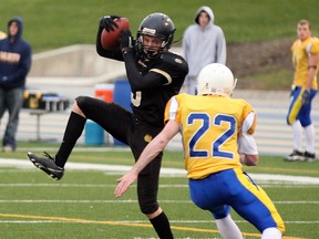 General Amherst receiver Adam Robinson, left, catches a pass in front of St. Anne's Jeff Rivait at Alumni Field in 2010. (NICK BRANCACCIO/The Windsor Star)