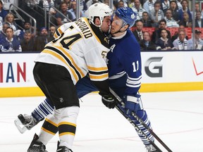 Boston's Adam McQuaid, right, battles against Jay McClement of the Maple Leafs. (Photo by Claus Andersen/Getty Images)