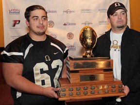 AKO Fratmen lineman John Muresan, left, and  head coach Mike LaChance display the Ontario Football Conference Championship Teddy Morris Memorial Trophy during a news conference in LaSalle, Ontario on October 22, 2013.  JASON KRYK/The Windsor Star)