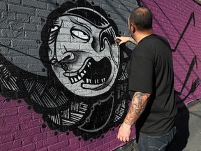 Artist Niko Burkes paints a mural in the alley near Maiden Lane in Windsor on Friday, October 11, 2013.  (TYLER BROWNBRIDGE/The Windsor Star)