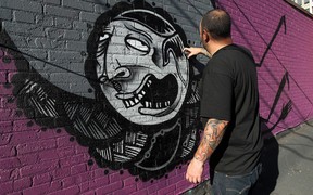 Artist Niko Burkes paints a mural in the alley near Maiden Lane in Windsor on Friday, October 11, 2013.  (TYLER BROWNBRIDGE/The Windsor Star)