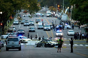 A damaged Capitol Hill police car is surrounded by crime scene tape on Constitution Avenue near the U.S. Capitol after a car chase and shooting Thursday, Oct. 3, 2013, in Washington. A woman with a young child inside tried to ram through a White House barricade, then led police on a chase toward the Capitol, where police shot and killed her, witnesses and officials said. (AP Photo/ Evan Vucci)