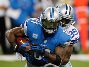 Calvin Johnson, left, of the Detroit Lions battles for extra yards while being tackled by Brandon Carr of the Dallas Cowboys October 27, 2013 in Detroit. (Gregory Shamus/Getty Images)