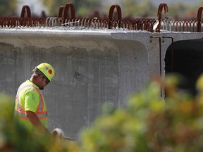 Unidentified workers inspect girders used for the Herb Gray Parkway project at a storage facility at the corner of Russell St. and Chappell Ave., Friday, Oct. 4, 2013.  (DAX MELMER/The Windsor Star)