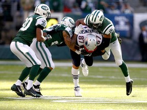 New York's Antonio Allen. right, Kyle Wilson and Darrin Walls, left, tackle New England's Rob Gronkowski at MetLife Stadium on October 20, 2013 in East Rutherford, N.J. The Jets beat the Patriots 30-27. (Jeff Zelevansky/Getty Images)