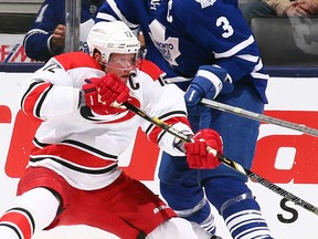 Leafs captain Dion Phaneuf, right, checks Carolina's Eric Staal at the Air Canada Centre October 17, 2013 in Toronto, Ontario, Canada.  (Photo by Abelimages/Getty Images)