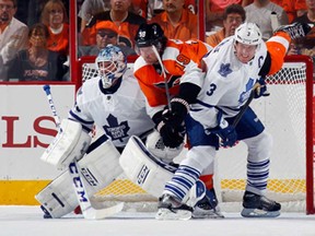 Toronto's Jonathan Bernier, left, gets into position as Leafs defenceman Dion Phaneuf battles Philadelphia's Scott Hartnell at the Wells Fargo Center on October 2, 2013 in Philadelphia.  (Photo by Bruce Bennett/Getty Images)