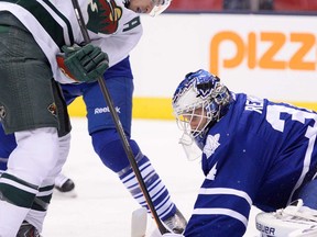 Maple Leafs goaltender James Reimer, right, makes a save on Minnesota's Zach Parise during first period NHL action in Toronto Tuesday October 15, 2013. (THE CANADIAN PRESS/Frank Gunn)