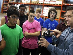 Ross Rawlings, right, president and founder of Radix Inc., gives a tour of his manufacturing facility to a group of Massey Secondary School students as part of Manufacturing Day on Friday.  (DAX MELMER / The Windsor Star)