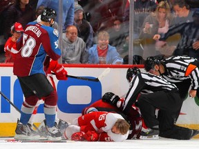 Detroit's Niklas Kronwall, centre, ays on the ice after being hit by Colorado Cody McLeod at Pepsi Center on October 17, 2013 in Denver. Kronwall was taken off the ice on a backboard and McLeod was charged with a boarding penalty and a game misconduct. (Doug Pensinger/Getty Images)