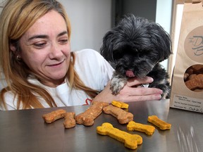 Stacy Drouillard of Doggy Bakery on Lincoln Road with dog model, Zoe, a Yorkie-poodle. Zoe was deciding which bone to pick, cheesy bites, left, or wheat-free pumpkin. (NICK BRANCACCIO / The Windsor Star)