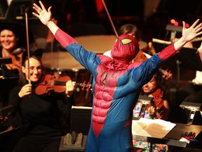 Conductor Jason Seber, tears out of his conductor uniform to transform into Spiderman during the Windsor Symphony Orchestra's Halloween Pops at the Capitol Theatre, Friday, Oct. 25, 2013.   (DAX MELMER/The Windsor Star)