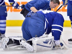 Maple Leafs goalie James Reimer is helped by a trainer after suffering a head injury 32 seconds into their game against the Carolina Hurricanes in Toronto on Thursday, Oct. 17, 2013. THE CANADIAN PRESS/Nathan Denette