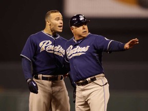 San Diego first base coach Rick Renteria, right, holds back Scott Hairston after being called out for interference against the San Francisco Giants  in San Francisco. (Ezra Shaw/Getty Images)