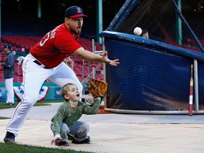 Boston's Ryan Lavarnway, left, catches a ball in front of Hank Drew, the son of Red Sox teammate Stephen Drew during a workout October 21, 2013 at Fenway Park in Boston. (Jared Wickerham/Getty Images)