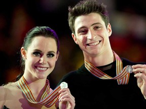 Ice dancers Tessa Virtue, of the University of Windsor, and Scott Moir show off their silver medals at the World Figure Skating Championships March 16, 2013 in London, Ont. Virtue and Moir will compete next week at Skate Canada International in Saint John, N.B. (THE CANADIAN PRESS/Paul Chiasson)