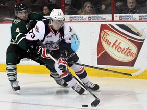 Spitfires forward Remy Giftopoulos, right, protects the puck against London defenceman Mike Liberati at the WFCU Centre Saturday, Oct. 19, 2013. The Spits beat the Knights 4-3. (JOEL BOYCE/The Windsor Star)