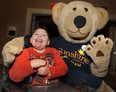 Luca Amaral, 7, of Leamington poses with a Sunshine Foundation mascot Monday, Oct. 21, 2013, at an information session for the DreamLift to Disneyland. He and dozens of other local children with disabilities will be heading to Florida early Tuesday morning for  day of fun.  (DAN JANISSE/The Windsor Star)