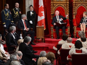 Prime Minister Stephen Harper, left, and Sharon Johnston, wife of the GG, look on as Governor General David Johnston delivers the Speech from the Throne in the Senate Chamber on Parliament Hill in Ottawa, Wednesday Oct. 16, 2013. (Sean Kilpatrick/The Canadian Press)