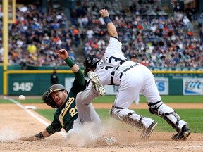 Oakland's Stephen Vogt slides into home plate to score a run in the fourth inning against Detroit's Alex Avila during Game 3 of the American League Division Series at Comerica Park on October 7, 2013 in Detroit. (Leon Halip/Getty Images)