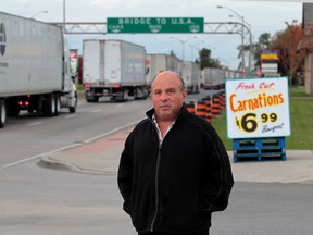 Fred Bouzide, owner of Fred's Farm Fresh looks at trucks backed up for kilometres on Huron Church Road in Windsor, Ontario on October 22, 2013.  (JASON KRYK/The Windsor Star)