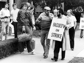 University of Windsor faculty members went on strike today at 8 a.m. on Sept. 20, 1982 after a marathon bargaining session throughout the weekend failed to solve a contract impasse with the university. French-language professor Peter Halford, (left), and Italian studies instructor Walter Temelini, carrying placard, joined other members of the faculty association, which represents lectures, professors and librarians, on the picket line today. The faculty association members walked off their jobs despite an early-morning offer from the university. The association met later in the morning to discuss the proposal. Meanwhile, thousands of students who showed up for classes this morning were caught in the middle of the dispute. (Walter Jackson/Windsor Star)