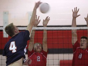 Sandwich's Tristan Thiessen, left, is blocked by Brennan's Jared Beens, centre, and Dylan Riley during WECSSAA boys volleyball action Tues. Oct. 22, 2013, in Windsor. The Sabres beat the Cardinals 2-1 (25-17, 25-19, 19-25). (DAN JANISSE/The Windsor Star)