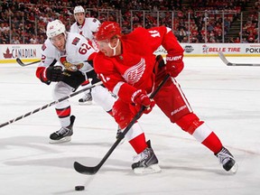 Detroit's Daniel Alfredsson, front, skates around Ottawa's Eric Gryba at Joe Louis Arena on October 23, 2013 in Detroit, Michigan. (Photo by Gregory Shamus/Getty Images)