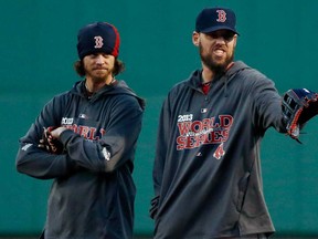 Boston pitchers Clay Buchholz, left, and John Lackey stand together during a workout at Fenway Park in Boston, Tuesday, Oct. 29, 2013. Lackey is scheduled to start Game 6 of baseball's World Series against the St. Louis Cardinals Wednesday in Boston. (AP Photo/Elise Amendola)