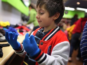 Hadi Abouel El Joud, 6, tries on a pair of gloves at Coats for Kids at the Unemployed Help Centre, Saturday, Nov. 2, 2013.  (DAX MELMER/ The Windsor Star)