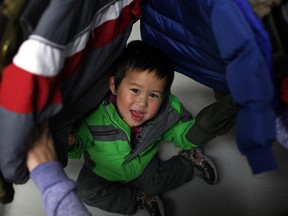 Barry, 2, (last name not given) plays hide and seek in a rack of winter jackets at Coats for Kids at the Unemployed Help Centre, Saturday, Nov. 2, 2013.  (DAX MELMER/ The Windsor Star)