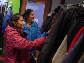 Hiri Pradhan, left, and Mila Pradhan, browse through racks of coats and jackets at Coats for Kids at the Unemployed Help Centre, Saturday, Nov. 2, 2013.  (DAX MELMER/ The Windsor Star)