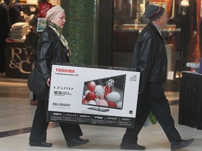 Miniona Tcherkezova, left, and Naum Ziskind carry a new television at the Devonshire Mall on Black Friday, Nov. 29, 2013, in Windsor.    (DAN JANISSE/The Windsor Star)