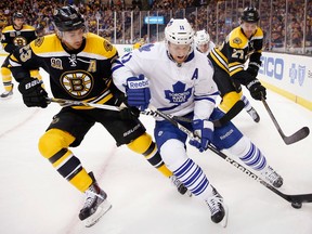 Toronto's Jay McClement, right, is checked by Boston's Chris Kelly Saturday. (AP Photo/Michael Dwyer)