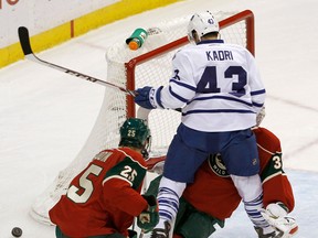 Toronto's Nazem Kadri, centre, collides with Minnesota goalie Niklas Backstrom Wednesday. (AP Photo/Ann Heisenfelt)