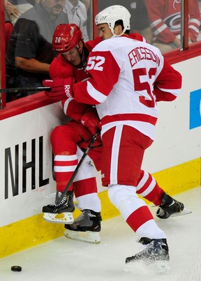 Detroit's Jonathan Ericsson, right, checks Riley Nash of the Hurricanes. (Photo by Grant Halverson/Getty Images)