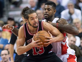 Toronto's Amir Johnson, right, guards Chicago's Joakim Hoah in Chicago Friday. (THE CANADIAN PRESS/Nathan Denette)