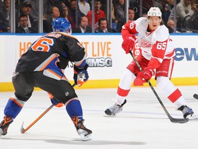 Detroit's Danny DeKeyser, right, is watched by New York's Matt Donovan at the Nassau Veterans Memorial Coliseum Saturday. (Photo by Al Bello/Getty Images)