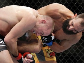 Johny Hendricks, right, punches Georges St. Pierre during a UFC 167 mixed martial arts championship welterweight bout Saturday in Las Vegas. (AP Photo/Isaac Brekken)