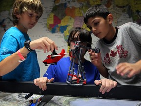 Curtis Paquette, left, Eric Campbell and Nabil Barchale, right,  members of VerifastBots First Lego Robotics Team are competing in the FIRST Lego Robotics Nature's Fury 2013 Challenge. In photo, students prepare a Lego cargo plane launch, part of their comprehensive project at CentreLine on Morton Drive Tuesday November 19, 2013. (NICK BRANCACCIO/The Windsor Star)