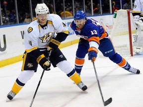 Ex-Spitfire Ryan Ellis, left, is checked by New York's Colin McDonald in Uniondale. (AP Photo/Kathy Kmonicek)