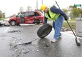 A worker removes debris from the scene of a crash between a Dodge Ram pick-up truck and a Dodge Caravan on Front Road and County Road 10 in Amherstburg on Nov. 6, 2013. (Dan Janisse / The Windsor Star)