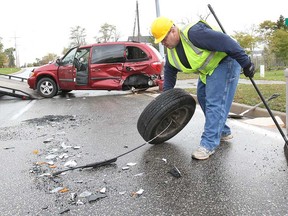 A worker removes debris from the scene of a crash between a Dodge Ram pick-up truck and a Dodge Caravan on Front Road and County Road 10 in Amherstburg on Nov. 6, 2013. (Dan Janisse / The Windsor Star)