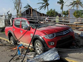 A damaged vehicle and houses in the aftermath of Super Typhoon Haiyan in Iloilo on November 10, 2013. Tormented survivors of a typhoon that is feared to have killed more than 10,000 in the Philippines rummaged for food on November 10 through debris scattered with corpses, while frenzied mobs looted aid convoys. (Tara YapTARA YAP/AFP/Getty Images)