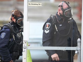 Two Windsor police officers enter an apartment building in the 900 block of Howard Ave. on Tues. Nov. 26 in Windsor, Ont. The officers were wearing oxygen masks after reports that pepper spray was used during a dispute. Ambulance and Windsor fire also attended.   (DAN JANISSE/The Windsor Star)