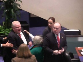 Toronto Mayor Rob Ford is shown in a video frame grab as he knocks down Councillor Pam McConnell as he ran toward hecklers in the audience at City Hall on Monday, Nov. 18, 2013. (THE CANADIAN PRESS/Paola Loriggio)